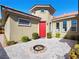 Inviting front entryway with a red front door, beautiful pavers, and a cozy fire pit at 77 Chapman Heights St, Las Vegas, NV 89138