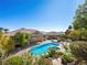 An inviting backyard pool surrounded by lush landscaping and a serene patio area at 77 Chapman Heights St, Las Vegas, NV 89138