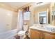 Cozy bathroom with tub and shower, wooden vanity and framed mirror at 7860 Thunder Echo St, Las Vegas, NV 89131