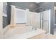 Bathroom featuring a soaking tub with shower and tiled walls at 7860 Thunder Echo St, Las Vegas, NV 89131