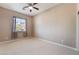 Bright bedroom featuring neutral walls, a ceiling fan, and a window with backyard views at 7860 Thunder Echo St, Las Vegas, NV 89131