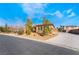 An exterior view of the house showcasing a long driveway leading to a well-maintained home and a secure gate at 7860 Thunder Echo St, Las Vegas, NV 89131