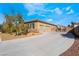 An exterior view of a large three car garage with a wide drive way and desert landscaping at 7860 Thunder Echo St, Las Vegas, NV 89131