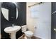 Modern half bath featuring a pedestal sink, black accent wall, and tile floors at 7860 Thunder Echo St, Las Vegas, NV 89131