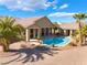 Backyard view of a Desert home with a sparkling pool, covered patio, and desert landscaping at 7860 Thunder Echo St, Las Vegas, NV 89131