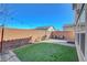 Cozy backyard featuring synthetic grass, string lights, and a brick perimeter wall for added privacy at 7870 Formitch Ct, Las Vegas, NV 89166