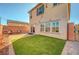 A private backyard has artificial grass, brick pavers, and a charming patio for entertaining at 7870 Formitch Ct, Las Vegas, NV 89166