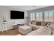 Living room features wood floors, gray walls, sectional sofa, shutters, and flat screen TV at 7870 Formitch Ct, Las Vegas, NV 89166