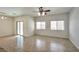 Spacious living room features tile flooring, ceiling fan, and sliding glass door at 8429 Spirit Vale Ave, Las Vegas, NV 89117