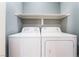 Efficient laundry area with washer, dryer, and overhead shelving at 8452 Boseck Dr # 285, Las Vegas, NV 89145