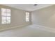 A carpeted bedroom with neutral paint and two windows for natural light at 8605 Wild Diamond Ave, Las Vegas, NV 89143