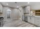 Bright kitchen features stainless steel appliances, light gray cabinets, and wood-look flooring at 8605 Wild Diamond Ave, Las Vegas, NV 89143