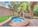 Outdoor hot tub and fireplace, surrounded by landscaping and privacy wall at 8629 Estrelita Dr, Las Vegas, NV 89128