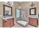 Beautiful bathroom with dual sinks, decorative mirrors, a glass shower, and elegant light fixtures at 8629 Estrelita Dr, Las Vegas, NV 89128