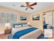 Staged bedroom with neutral tones, ceiling fan, and shuttered windows at 8629 Estrelita Dr, Las Vegas, NV 89128