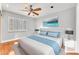 Staged bedroom featuring bright walls, shuttered windows, and an accent wall at 8629 Estrelita Dr, Las Vegas, NV 89128