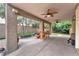 Spacious covered patio with ceiling fans, dining area, and views of the lush backyard at 8629 Estrelita Dr, Las Vegas, NV 89128
