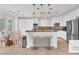 Bright kitchen boasts white cabinetry, stainless steel appliances, and a breakfast bar with stylish pendant lighting at 8629 Estrelita Dr, Las Vegas, NV 89128