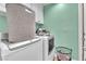 Bright laundry room with modern washer and dryer, white cabinets, and colorful wall at 8629 Estrelita Dr, Las Vegas, NV 89128