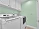 Well-lit laundry room features a full-size washer, dryer, and ample storage within white cabinetry at 8629 Estrelita Dr, Las Vegas, NV 89128