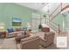 Cozy living room with a tan sofa, blue pillows, and elegant staircase at 8629 Estrelita Dr, Las Vegas, NV 89128