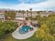 Aerial shot of a backyard oasis featuring a rock waterfall pool, tiki hut, and lush landscaping at 8970 Lansberry Ct, Las Vegas, NV 89147