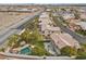 Wide aerial view of a home featuring a backyard oasis complete with a pool, tiki hut, and lush landscaping at 8970 Lansberry Ct, Las Vegas, NV 89147