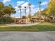 Large backyard with a custom pool featuring a waterfall, slide, tiki hut, and ample green space at 8970 Lansberry Ct, Las Vegas, NV 89147