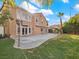 Backyard view with a large patio, lawn area, and lush landscaping at 8970 Lansberry Ct, Las Vegas, NV 89147