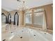 Open dining area showcasing large windows, elegant chandelier, tiled floors, and modern curtains at 8970 Lansberry Ct, Las Vegas, NV 89147