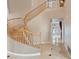 Grand entryway featuring a curving staircase with wood railing and tile flooring at 8970 Lansberry Ct, Las Vegas, NV 89147