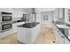 Modern kitchen featuring stainless steel appliances, island cooktop, white cabinetry, and ample counter space at 8970 Lansberry Ct, Las Vegas, NV 89147