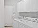 Laundry room with white washer and dryer and white cabinets at 8970 Lansberry Ct, Las Vegas, NV 89147