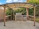 Outdoor kitchen featuring a built-in grill, counter space, and a pergola providing shade at 8970 Lansberry Ct, Las Vegas, NV 89147