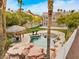 Backyard pool with rock waterfall feature and tiki hut surrounded by lush tropical landscaping and grass at 8970 Lansberry Ct, Las Vegas, NV 89147