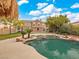 Backyard with a large pool, lush lawn, and the home's exterior in the background at 8970 Lansberry Ct, Las Vegas, NV 89147