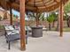 Relaxing tiki hut featuring comfortable seating and a fire pit, perfect for outdoor entertaining at 8970 Lansberry Ct, Las Vegas, NV 89147