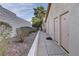 Low rise apartment building with light pink doors and rock landscaping on an overcast day at 905 Rockview Dr # 101, Las Vegas, NV 89128