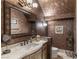 Stylish powder room with large mirror, granite counter, and patterned wallpaper at 9325 Verlaine Ct, Las Vegas, NV 89145