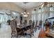 Formal dining room featuring designer table and chairs, travertine floors, and large windows at 9325 Verlaine Ct, Las Vegas, NV 89145