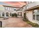 Luxurious estate with fountain, arched windows, and balcony overlooking the expansive patterned concrete courtyard at 9325 Verlaine Ct, Las Vegas, NV 89145