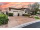 Attached two-car garage with patterned concrete driveway, trimmed hedges, and mature landscaping at 9325 Verlaine Ct, Las Vegas, NV 89145