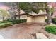 Spacious three-car garage featuring a patterned concrete driveway and mature landscaping at 9325 Verlaine Ct, Las Vegas, NV 89145