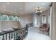 Hallway featuring a wrought iron railing, elegant chandelier, and many windows at 9325 Verlaine Ct, Las Vegas, NV 89145