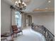 Elegant hallway with wrought iron railing, arched window, and decorative chandelier at 9325 Verlaine Ct, Las Vegas, NV 89145