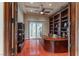 This home office features custom built-in shelves, a ceiling fan, and hardwood floors at 9325 Verlaine Ct, Las Vegas, NV 89145