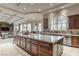 Spacious kitchen features a large island, custom cabinets, stone counters and stainless steel appliances at 9325 Verlaine Ct, Las Vegas, NV 89145