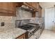 Gourmet kitchen featuring stainless steel appliances, custom range hood, and granite countertops at 9325 Verlaine Ct, Las Vegas, NV 89145