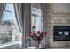 Bright living room with stone fireplace and large windows offering scenic views of the surrounding landscape at 9325 Verlaine Ct, Las Vegas, NV 89145