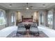 Large main bedroom with sitting area, tray ceiling, and arched windows for natural light and architectural detail at 9325 Verlaine Ct, Las Vegas, NV 89145